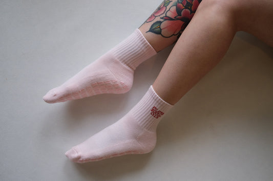 Pink grip socks with embroidered writing "pilates social club"